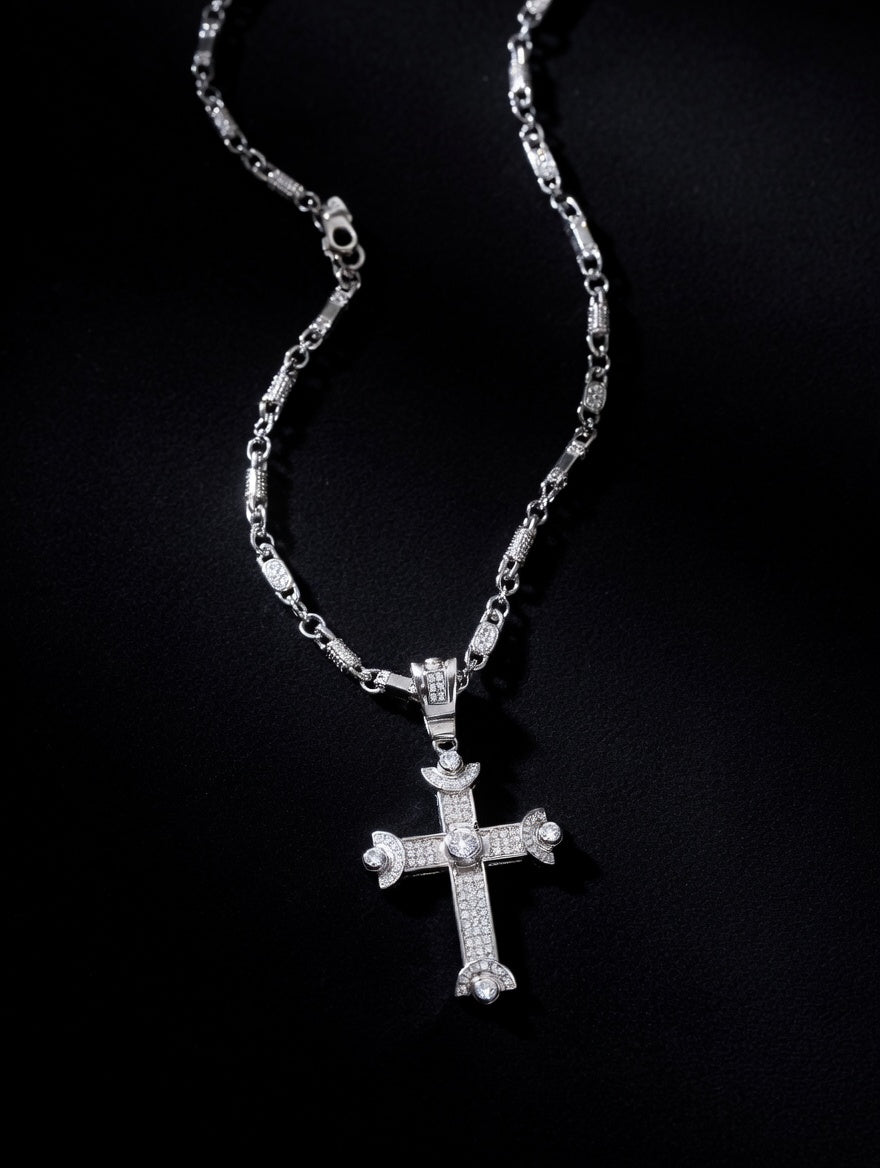 Barrel link chain on black background with silver cross pendant