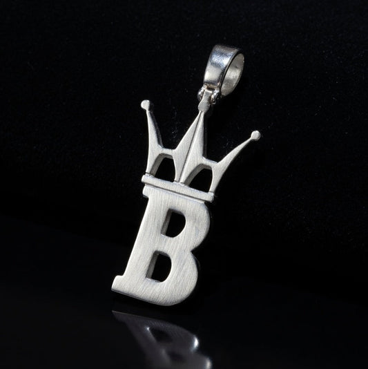 Silver pendant with letter 'B' and crown design on a black background