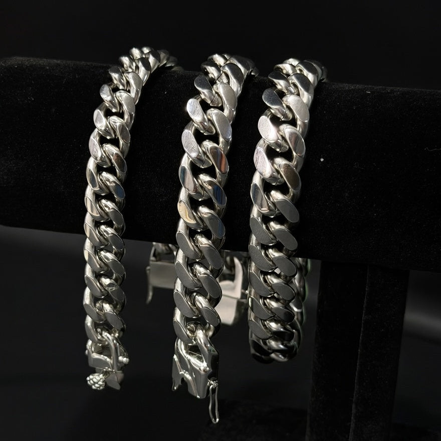 Set of Miami Cuban Silver chain bracelets on a black display and background