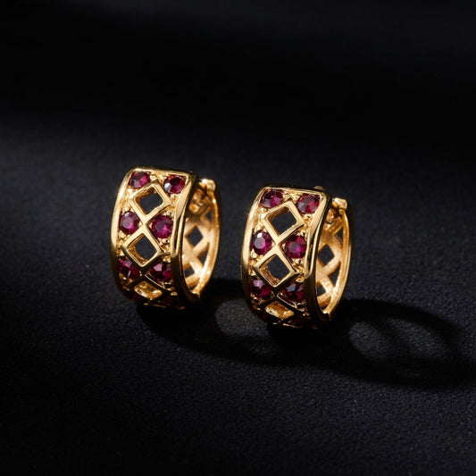 Gold hoop earrings with red gemstones on a black background