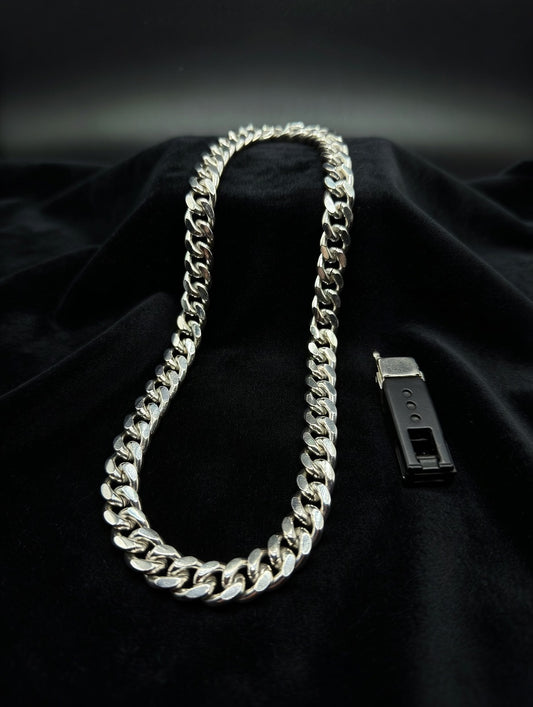Silver chain necklace on a black fabric background
